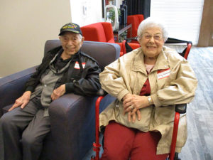 Two residents seated together in a lounge area, smiling and relaxing.