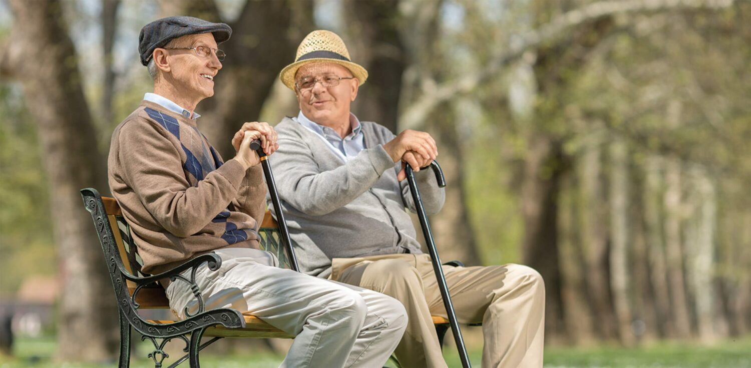 two senior residents enjoying eachother's company in a park at The Carrington at Lincolnwood