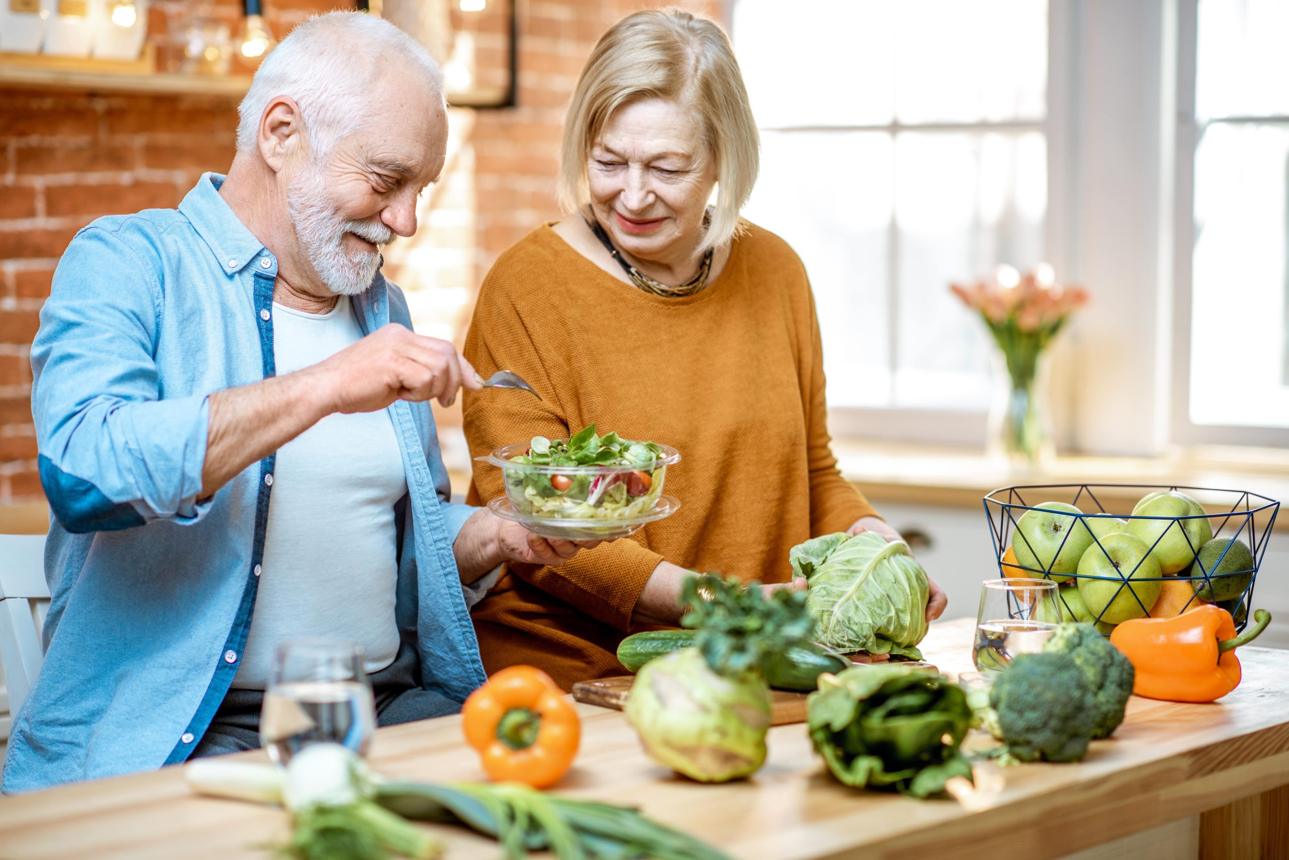 older male and female making healthy recipe